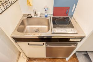 東京にあるsakura 202のシンクとコンロのある小さなキッチン