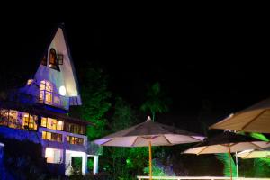 a lit up building with umbrellas in front of it at Pousada Chale da Montanha in Petrópolis +75 photos