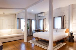 ein Schlafzimmer mit einem Bett und einer Couch in der Unterkunft Busaba Ayutthaya Hotel in Phra Nakhon Si Ayutthaya