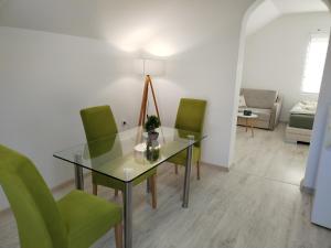 a dining room with a glass table and green chairs at Andrijana in Soko Banja +7 photos