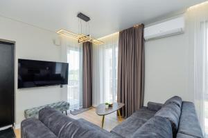 a living room with a couch and a flat screen tv at Baltic Harmony Apartments in Palanga