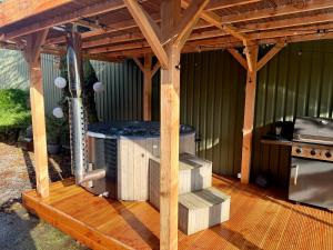 a wooden pergola with a stove on a deck at Holiday Home de Binnengouw incl Hottub in Hoogwoud +43 photos