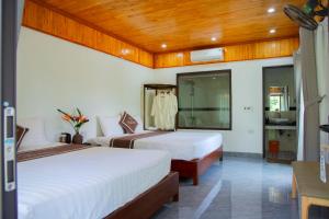 Una habitación de hotel con dos camas y un baño. en Tam Coc Kamili Bungalow & Homestay, en Ninh Binh