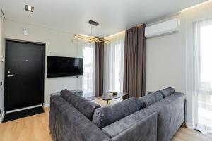 a living room with a large couch and a flat screen tv at Baltic Harmony Apartments in Palanga