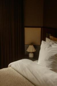 a bedroom with a white bed and a lamp at Four Suites Copenhagen in Copenhagen