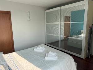 Un dormitorio con una cama con toallas. en 5 min to Equieffe & Private Parking - Teo House, en Gorla Maggiore