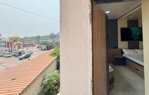 a room with a balcony with a view of a city at Trinetra Yatri Niwas in Aundah