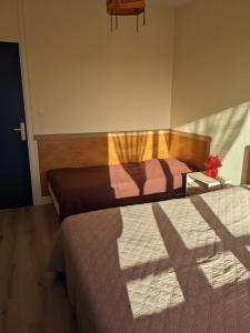 een slaapkamer met twee bedden en een schaduw op de vloer bij Maison centre de Barfleur in Barfleur