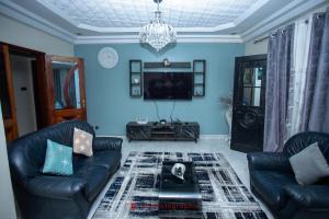 a living room with two leather couches and a tv at Residence Cabral in Guediawaye