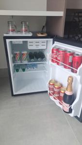 an open refrigerator with food and drinks in it at Pousada Pinocchio in Maricá