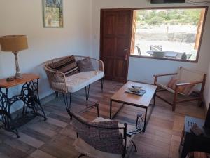 Una sala de estar con una silla y una mesa. en Cabañas La Nochera, en Tilcara 12 fotos más