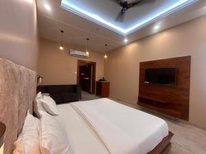 a bedroom with a bed and a flat screen tv at The Satluj Vista in Bilāspur