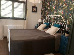 1 dormitorio con 1 cama grande y papel pintado con motivos florales en Wéber Villa, en Gyenesdiás
