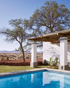 ein Swimmingpool vor einem Haus in der Unterkunft Noois’hof Sinclair Nature Reserve in Helmeringhausen