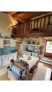 een woonkamer met een tafel en een keuken bij Maison Le puits du bonheur in La Villedieu