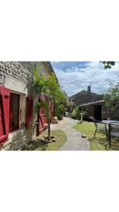 una casa de piedra con una mesa y un banco en Maison Le puits du bonheur, en La Celle-sous-Gouzon