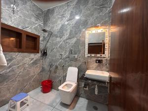 a bathroom with a white toilet and a sink at The Satluj Vista in Bilāspur