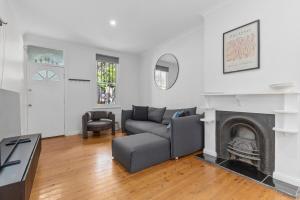 a living room with a couch and a fireplace at Comfortable 3BR Home for 8 Near Central Station in Sydney