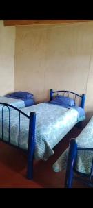 two twin beds in a room with blue sheets at Cabañamymemprende in La Unión