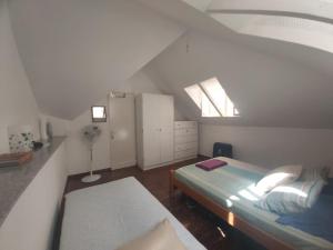 Dormitorio pequeño en el ático con cama y ventana en FeliGrab, en Mindelo