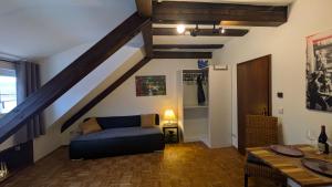 a living room with a blue couch and a staircase at Klosterblick in Gengenbach
