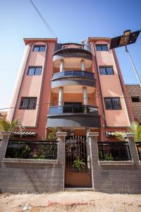 a pink building with a gate in front of it at Residence Cabral in Guediawaye