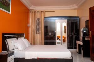 a bedroom with a bed and an orange wall at Residence Cabral in Guediawaye