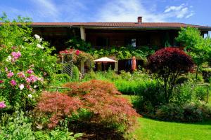 a garden in front of a house with flowers at Zum Friedl in Wackersberg