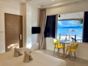 a bedroom with a bed with a view of the ocean at South Beach Inn in Amphoe Koh Samui