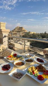a table with plates of food on a balcony at Negmet Siwa Hotel in Siwa