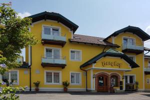 un edificio amarillo con un letrero que lee la universidad en Pension Baumgartner-Berghof, en Obernberg am Inn