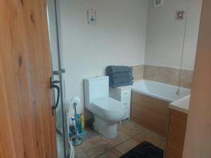 ein Badezimmer mit Toilette, Badewanne und Waschbecken in der Unterkunft Coastline cottage in Pakefield + 13 Fotos