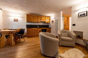 a kitchen with wooden cabinets and a table and chairs at Lo Péyo - Le Four des Alpes in Rhemes-Saint-Georges