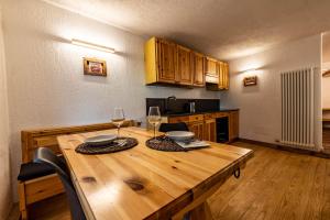 eine Küche mit einem Holztisch mit zwei Gläsern Wein in der Unterkunft Lo Péyo - Le Four des Alpes in Rhemes-Saint-Georges