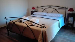 una camera da letto con letto, lenzuola e cuscini bianchi di B&B Il Giardino sull'Alento a Prignano Cilento