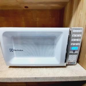 einem weißen Mikrowellenherd auf einer Theke in der Unterkunft bairro Vila bandeirantes - apto 3 quartos com ar condicionado em condomínio in Campo Grande