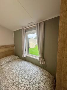 Fenny Bentley28 Fentley Green - Ashbourne Heights Holiday Park的一间卧室，里面有一张床和一扇窗户。 更多9张照片