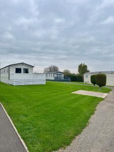 Fenny Bentley28 Fentley Green - Ashbourne Heights Holiday Park的一片大片草地,有建筑背景