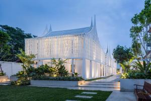 ein großes weißes Gebäude mit spitzem Dach in der Unterkunft Busaba Ayutthaya Hotel in Phra Nakhon Si Ayutthaya