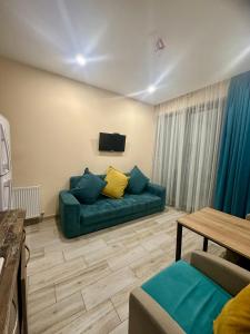a living room with a green couch and a table at Snow Forest ԲԱԿՈՒՐԻԱՆԻ-ბაკურიანი-BAKURIANI in Bakuriani