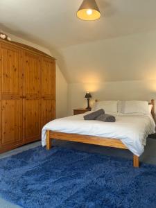 a bedroom with a large bed and a blue rug at Charming cottage close to the Cairngorms in Ballindalloch