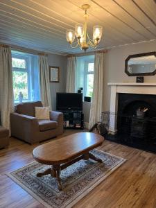a living room with a couch and a coffee table at Charming cottage close to the Cairngorms in Ballindalloch