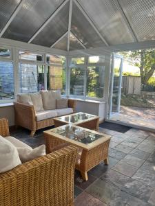 a screened in porch with a couch and a table at Charming cottage close to the Cairngorms in Ballindalloch +19 photos