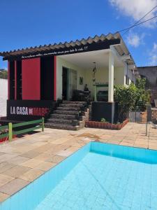 a house with a swimming pool in front of a building at Hostel La Casa de Mabel in Natal