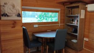 a dining room with a table and chairs and a window at Chalet avec salle d'eau in Chavagne
