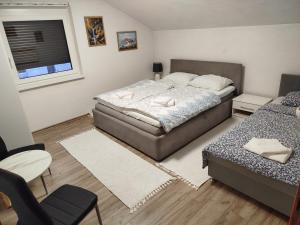 a small bedroom with two beds and a window at Apartmani LIDER Visoko in Visoko