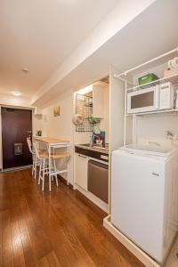 a kitchen and dining room with a table and a microwave at sakura 201 in Tokyo