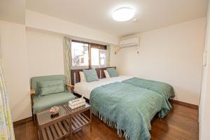 a bedroom with a bed and a green chair at sakura 201 in Tokyo