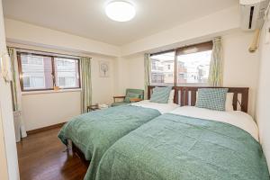 two beds in a room with two windows at sakura 201 in Tokyo