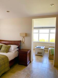 Un dormitorio con una cama y una mesa y una ventana. en Craig-Y-Mor Suites With Sea Views Whitesands Bay St Davids, en St. Davids